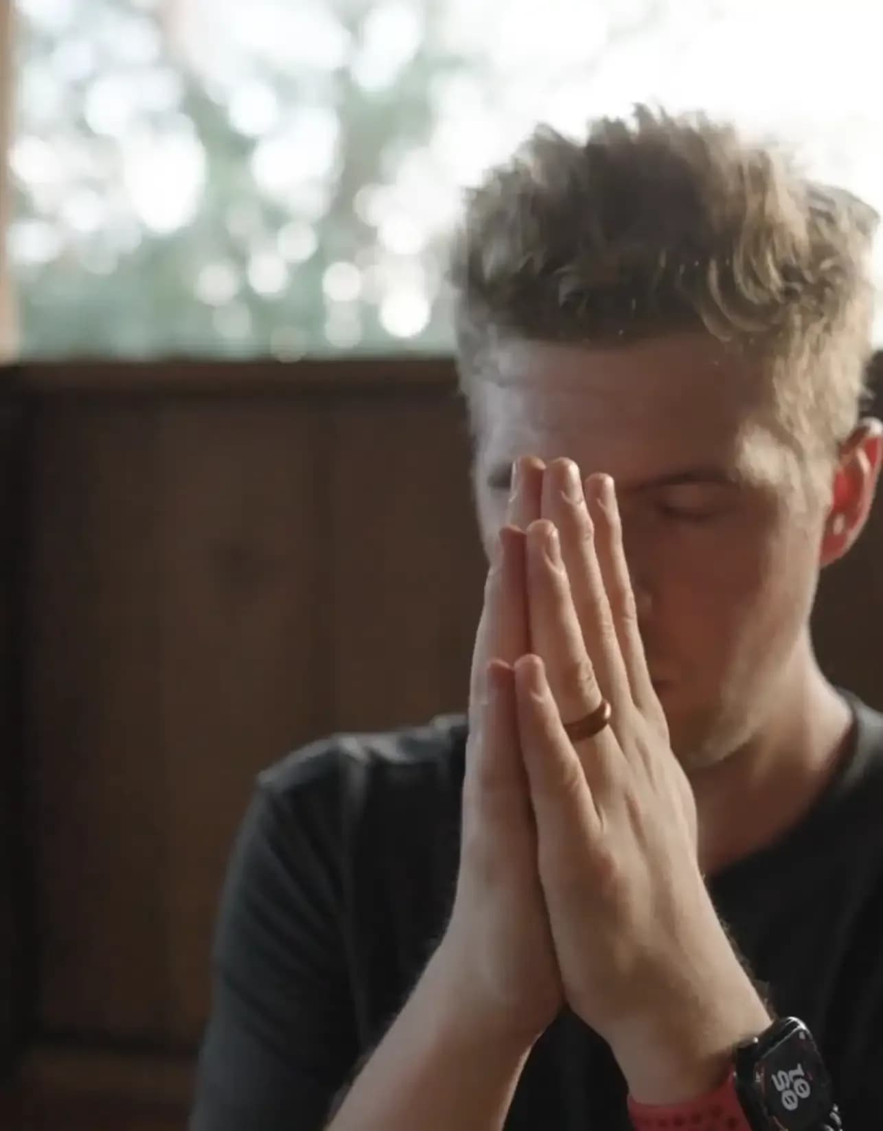 Person with hands in prayer during a reflective moment